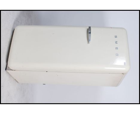 A 20th century SMEG Fridge of upright form having chrome SMEG notation to front and white enamel paintwork