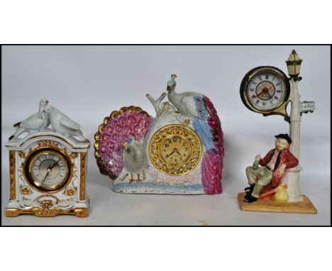A group of three vintage kitsch ceramic mantel clocks. One in the form of a peacock, one in the form of doves and another. Me
