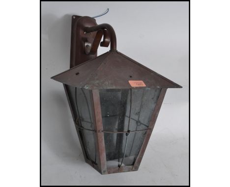 A 20th century Arts and Crafts style external wall light, having original wall fitting bracket, in the form of a lantern.
