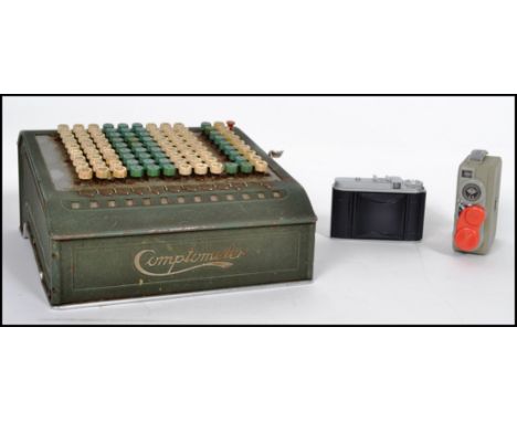 A vintage industrial comptometer counting machine along with a pair of 35mm cameras, one being a Voight lander and the other 