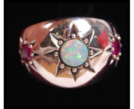 A silver opal and garnet stone adorned 3 stone gypsy ring, each stone being starburst mounted. Total weight 8.2g &nbsp;/ Size