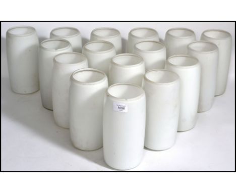 A 20th century collection of tall cylindrical glass milk lamp shades. 