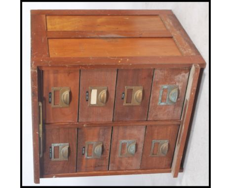 A vintage 130's / 40's oak industrial drawers, set within a block of eight having brass cup handles and name spacers. Raised 