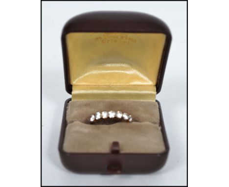 A vintage hallmarked 9ct gold 7 stone ring having split shoulders with the stones set in a prong mount. Weighs 2 grams bearin