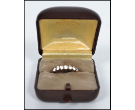 A vintage hallmarked 9ct gold 7 stone ring having split shoulders with the stones set in a prong mount. Weighs 2 grams bearin