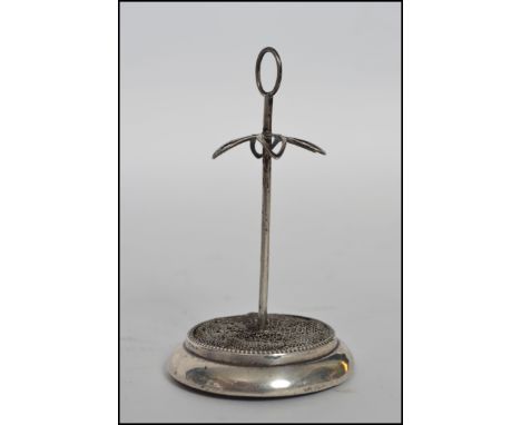 A hallmarked silver hat pin stand of plain design with a hoop top, with a pierced platform to support hat pins raised on a ci