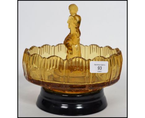 An early 20th century pressed glass centre piece bowl having a raised edge with central figure of a maiden raised on a frog p