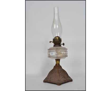 An early 20th-century duplex oil lamp having a flute raised above a faceted reservoir on top of a cast metal square pyramid w