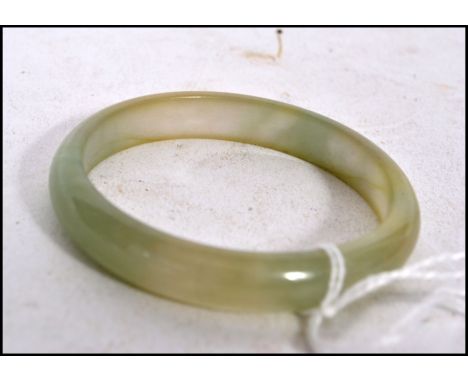 A Chinese pale Celadon to green jade bangle being  unsigned in a  good condition 