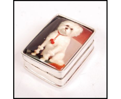 A silver rectangular pill box with a hinged enamel top having pictorial scene of a West Highland Terrier - Scottie Dog. Total