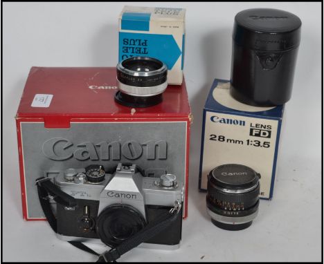 A vintage Canon FTb slr camera body complete in the box together with a cased Auto Tele Plus 2 x converter lens and a Canon 2