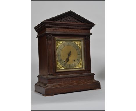 An architectural Victorian oak mantel clock, an arch pediment raised on columns and carved brick work design. The clock havin