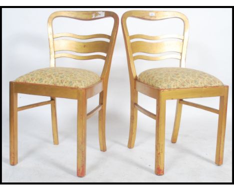 A pair of 1950's town hall chairs having gilt finisha with shaped back rests and tapestry upholstered seats