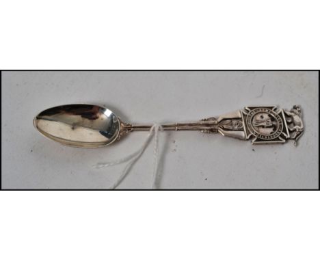 An unusual silver Army Rifle Association teaspoon with decorative and oval bowl. Hallmarks for Birmingham, date letter X, mak