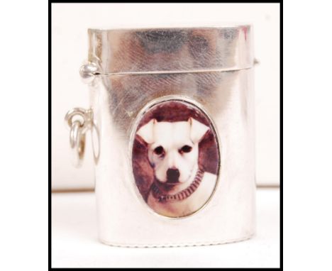 A silver barrel vesta case with an enamel pictorial lozenge with scene of a dog to the front. Hinged top above, strike to bas