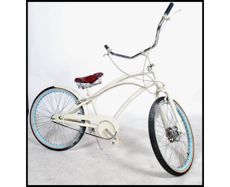 A vintage 20th century fixed speed beech cruiser bike, having an over sized low saddle, sweeping frame and fantastic Cowhorn 