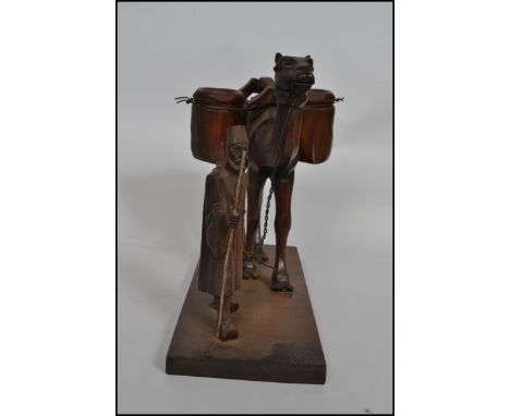 A 1930s  Arabic hand carved centrepiece condiment - table salt stand. Raised on a wooden plinth base with carved merchant man