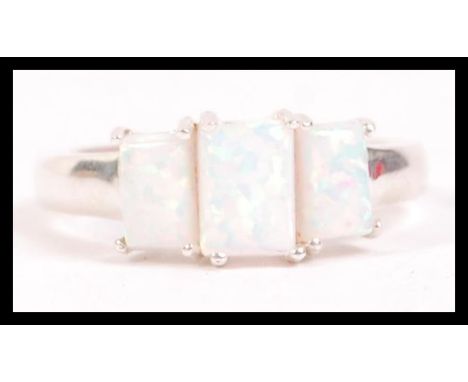 A ladies 20th century silver and opal adorned 3 stone dress ring. Each opal being cushion cut and claw mounted. Total weight 