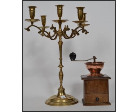 A vintage table centre brass five point candelabra together with a vintage wooden and copper coffee grinder.