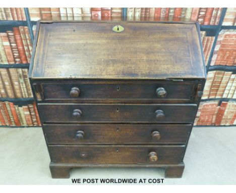 A mahogany bureau with four drawers, opening to reveal nine compartments and four drawers with turned ivory knobs, raised on 