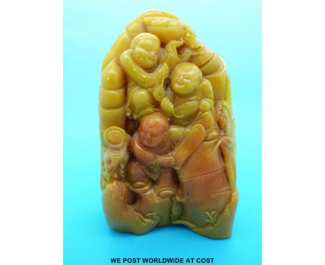 An unusual carved yellow soapstone boulder with three figures holding fruit and other items (15cm tall)