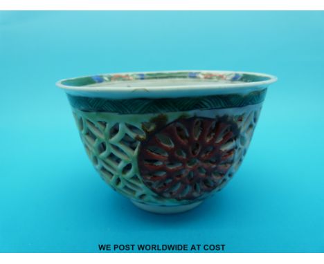 A Chinese, Kangxi period (1662-1772) famille verte reticulated tea bowl decorated with various auspicious symbols (5.5cm tall