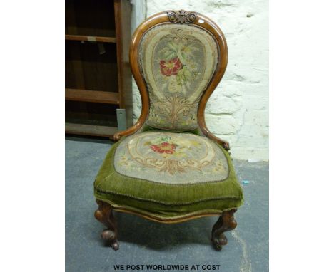 A Victorian walnut carved spoon back button upholstered nursing chair with scroll turned ends, serpentine fronted with carved