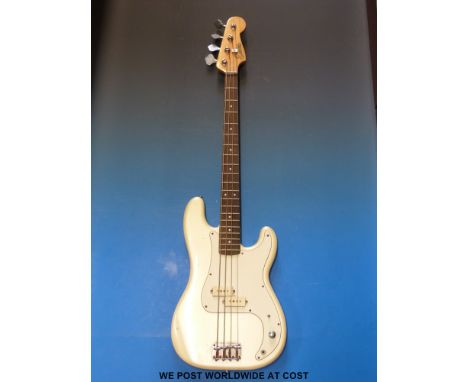 An Encore bass guitar in cream finish