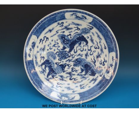 A 19thC Chinese blue and white charger decorated with three Fu dogs, Kangxi mark to base (38cm diameter)  