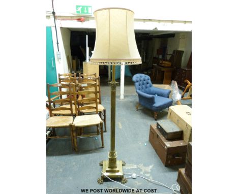 A brass Corinthian column standard lamp with lions paw feet. 