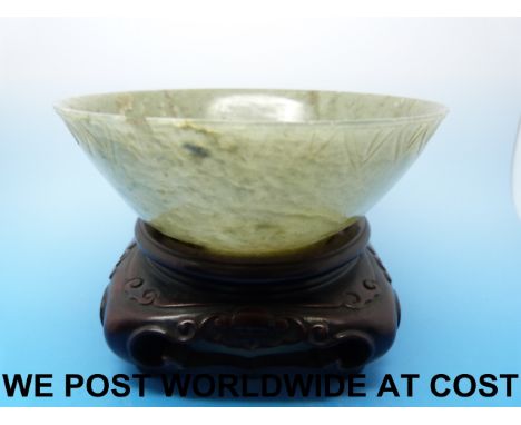 A carved Chinese spinach jade bowl on wooden stand, probably 18thC (11cm diameter)