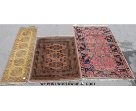 Three wool rugs, one geometric on pink ground (190cm x 118cm)  , one geometric on light brown ground (141 x 107cm), the other