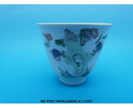 A Chinese, Kangxi period (1662-1722) famille verte flared lip tea bowl decorated with various flowers amongst rocks (7cm tall