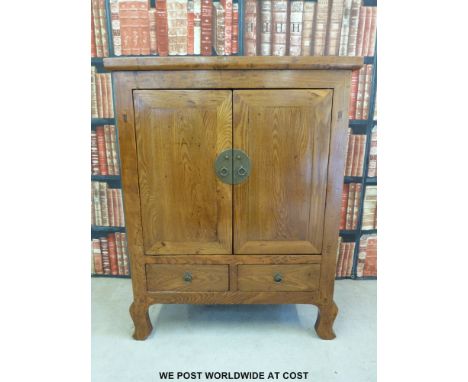 A Chinese elm two door cabinet with drawers under, raised on shaped front legs, originating from Sha'anxi Province, with orig